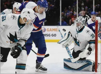  ?? JOHN MINCHILLO — THE ASSOCIATED PRESS ?? Sharks goaltender Martin Jones (31) and Islanders wing Anders Lee (27) eye a loose puck in Sunday’s contest.