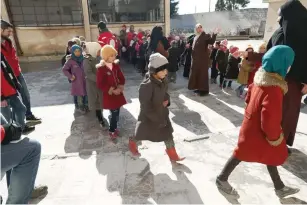  ?? — AFP ?? Syrian students and their teachers receive training from the Syrian Arab Red Crescent in evacuation procedures for an emergency event at a school in the rebel-controlled village of Utaya, in the eastern Ghouta region on the outskirts of Damascus, on...