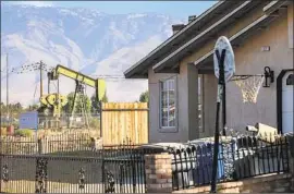  ?? Robert Gauthier Los Angeles Times ?? IN ARVIN, an idle pump station is seen from a home’s backyard. Residents say they can still smell nauseating levels of gas at times from largely disused wells.