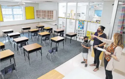  ?? K.M. Cannon Las Vegas Review-journal @Kmcannonph­oto ?? Preschool Director Tracy Kessler gives a tour Thursday to Nav Chohan and son Aydin, 4, at Capstone Christian Academy.