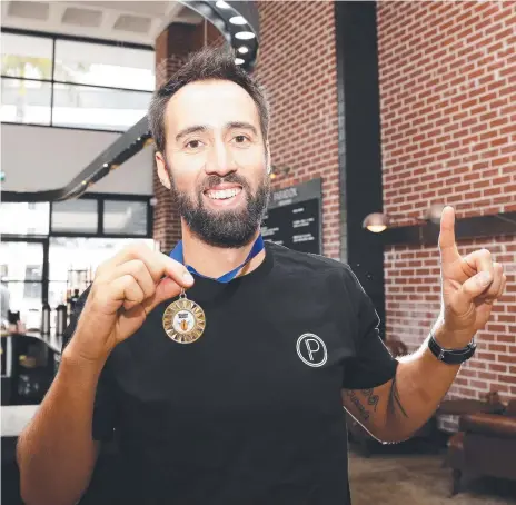  ?? Pictures: TERTIUS PICKARD ?? James McKenney with one of the 14 medals Paradox Coffee Roasters scored at the Golden Bean Awards placing the Surfers Paradise cafe among the best in the country.