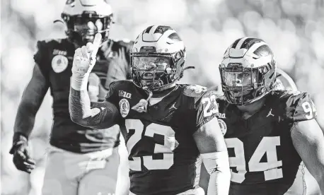  ?? ?? Linebacker Michael Barrett, center, and the Michigan defense made a stand against Alabama during the Rose Bowl.