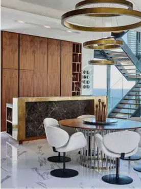  ??  ?? The bespoke walnut dining table with a marble lazy Susan, is surrounded by Arti-forte chairs, beside the stylish kitchen area.