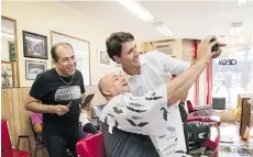  ?? KEVIN VAN PAASSEN/THE CANADIAN PRESS ?? Liberal leader Justin Trudeau takes a selfie with customer Peter Cepelak and barber Omid Ghemi in Aurora, Ont., on Thursday.