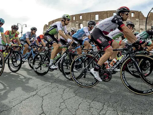  ??  ?? Al Colosseo I ciclisti al passaggio davanti all’Anfiteatro Flavio: asfalto dissestato, come in molte altre strade di Roma (foto LaPresse)