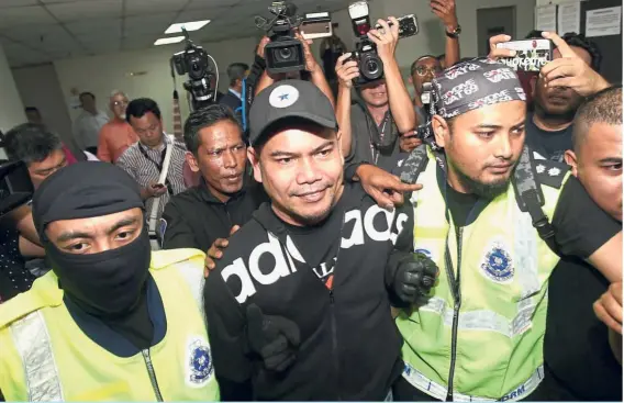  ?? — AZMAN GHANI/ The Star ?? Police officers escorting Datuk Seri Jamal Yunos to the Ampang magistrate’s court after he was deported from Indonesia.