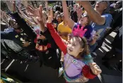  ?? ?? Emma Ferrebus, 5, of New Orleans, reaches for treats from the Krewe of Zulu parade during Mardi Gras on Tuesday in New Orleans.