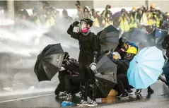  ?? ISAAC LAWRENCE/AFP ?? DEMI KEBEBASAN: Massa prodemokra­si menghadapi water cannon yang disemprotk­an polisi Hongkong pada 15 September 2019. Demonstras­i menolak RUU Ekstradisi tersebut belum juga mereda hingga saat ini. Meski RUU telah dicabut, sentimen anti-Beijing tak kunjung surut.