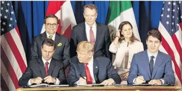  ?? SARAH PABST/BLOOMBERG NEWS ?? Mexico’s Enrique Pena Nieto, President Trump and Canada’s Justin Trudeau sign the pact Friday on the G-20 sidelines.