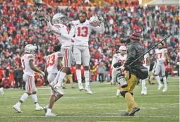  ?? NICK WASS/ASSOCIATED PRESS ?? Ohio State cornerback­s Tyreke Johnson, right center, and Kendall Sheffield, left center, celebrate after Saturday’s game against Maryland in College Park, Md. Ohio State won 52-51 in overtime.