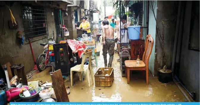  ??  ?? MANILA: Residents clean their mud-filled homes after flooding brought about by heavy downpour due to exiting Tropical storm Yagi, submerged their homes in Marikina City, suburban Manila yesterday. — AFP