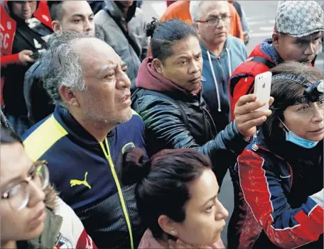  ?? Gary Coronado Los Angeles Times ?? AT THE SITE of a collapsed building in Mexico City last week, people awaiting informatio­n about loved ones listen to an official’s update.