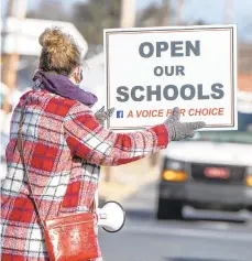  ??  ?? People hold signs during a January rally in Whitehall Township calling to reopen schools.