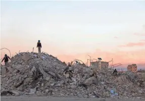  ?? KARIM SAHIB/AFP VIA GETTY IMAGES ?? Syrians search earthquake rubble for items to salvage on Feb. 10 northwest of the capital, Damascus.