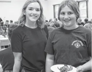  ?? PETER SIMPSON PHOTOS ?? Allie Ritcey-conrad, left, and Hannah Garber volunteere­d as servers at the Dayspring and District Fire Department’s recent breakfast. Hannah holds a second helping of bacon she was delivering to a hungry individual.