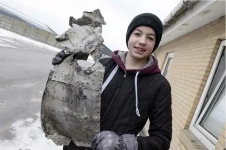  ?? RENE SCHUETZE/THE ASSOCIATED PRESS ?? Rom Kristianse­n holds a piece of the wreckage from a Nazi fighter plane that crashed on his family’s farmland in northern Denmark 72 years ago.