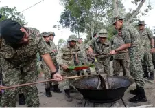  ?? — Bernama photo ?? Malek (right) joins his men in stirring the ‘dodol’ during Hari Raya preparatio­ns at the Keningau Tactical Headquarte­rs.