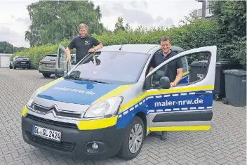  ?? FOTO: INA BODENRÖDER ?? Werbetechn­iker Denis Jörgens und Maler Lutz Gusowski (r.) zeigen das Firmenfahr­zeug des Malermeist­ers, das ganz bewusst ähnlich zu einem Streifenwa­gen gestaltet wurde. Ob’s erlaubt ist, das hat vorher ein Anwalt geklärt.