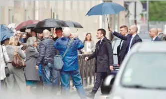  ?? — AFP ?? France’s president-elect Emmanuel Macron walks in a street in Paris.