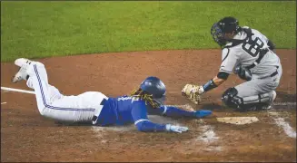  ?? AP PHOTO ADRIAN KRAUS ?? Toronto Blue Jays’ Vladimir Guerrero Jr. scores as New York Yankees catcher Kyle Higashioka reaches to make a tag, on a double by Alejandro Kirk during the sixth inning of a baseball game in Buffalo, N.Y., Thursday.