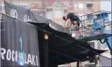  ?? GARY NYLANDER/The ?? Josh Winterlik, with SW Audio Visual, moves a banner on a large stage while setting up for the Rock the Lake music festival in the parking lot of Kelowna’s Prospera Place on Thursday.