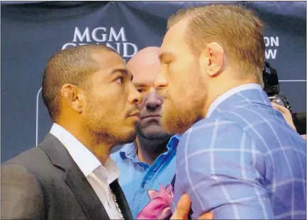  ?? — THE CANADIAN PRESS FILES ?? UFC fans may have to wait to see featherwei­ght champion Jose Aldo, left, and challenger Conor McGregor square off. UFC president Dana White stands between the fighters.