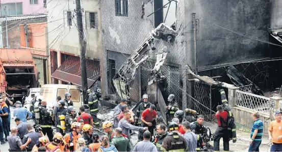  ?? ALEX SILVA / ESTADAO ?? Acidente. Bombeiros atuaram para extinguir as chamas e retiraram os corpos do piloto e do copiloto do interior da aeronave; explosão assustou vizinhos