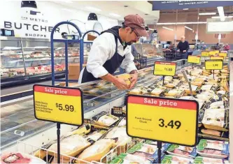  ?? JOURNAL SENTINEL FILES ?? Christian Castaneda stocks chicken at Metro Market in Shorewood.