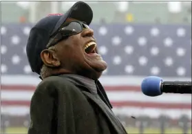  ?? ?? Ray Charles sings “America The Beautiful” in the rain at Fenway Park in Boston on April 11, 2003.