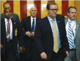  ?? (Jonathan Ernst/Reuters) ?? US VICE PRESIDENT Mike Pence (second left) is escorted through the Capital rotunda after casting the tie-breaking vote in the Senate yesterday.