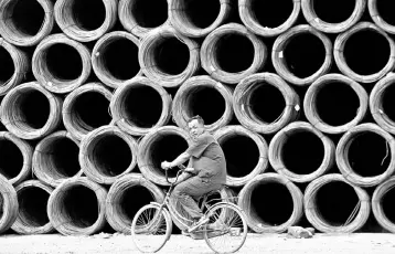  ??  ?? A labourer cycles past coils of steel wire at a steel wholesale market in Shenyang, Liaoning province. Profits for China’s industrial powerhouse­s surged the most in nearly six years in September as a government crackdown on air pollution sparked fears...