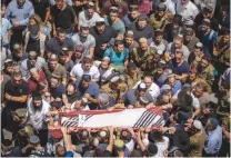  ?? (Yonatan Sindel/Flash90) ?? MOURNERS CARRY the body of Yehuda Guetta during his funeral in May.