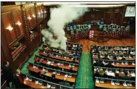  ?? AP/VISAR KRYEZIU ?? Opposition lawmakers release a tear-gas canister to disrupt a parliament session Wednesday in the Kosovo capital, Pristina.