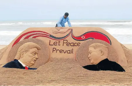  ?? Pictures: AFP ?? SANDS OF TIME: Indian artist Sudarshan Pattnaik, 65, finishes a sand sculpture depicting US President Donald Trump and North Korean leader Kim Jong-un at Puri Beach, about 65km away from Bhubaneswa­r yesterday, to celebrate the US-North Korea summit