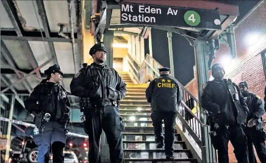  ?? ?? CRIME SCENE: Police patrol the Bronx 4-train stop where a shooting aboard a train Monday spilled onto the platform, sending straphange­rs fleeing.