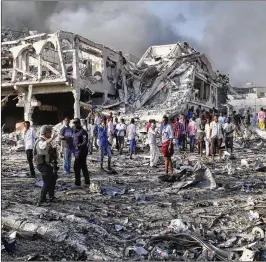  ?? FARAH ABDI WARSAMEH / AP ?? Somalis gather and search for survivors at the scene of a blast in the capital Mogadishu on Saturday. An explosion from a truck bomb killed at least 20 people, police said, as residents called it the most powerful blast they had heard in years.