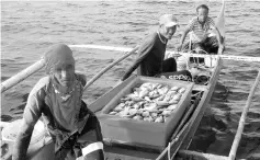  ??  ?? Three of the four foreigners with the pump boat and fish that were seized.