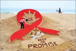  ??  ?? Sandartist Sudersan Pattnaik gives the final touches to a sand sculpture on the eve of World AIDS Day on Golden Sea Beach at Puri in Orissa. World AIDS Day is celebrated on December 1, every year to raise awareness about HIV/AIDS and to demonstrat­e...