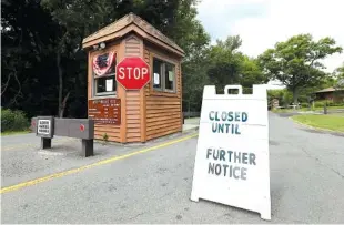  ?? ASSOCIATED PRESS PHOTOS ?? Above: A sign sits at the entrance of Cheesequak­e State Park on Saturday. The park remains closed due to the New Jersey government shutdown. Left: New Jersey Gov. Chris Christie addresses a joint session of the Democrat-led Legislatur­e at the...