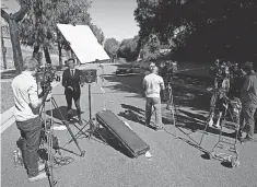  ?? ASHLEY LANDIS/ AP ?? Members of the media gather near the spot where Tiger Woods’ vehicle crashed early Tuesday outside Los Angeles. Woods was alone in the car.