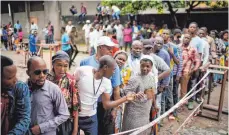  ?? FOTO: DPA ?? Wähler warten vor einem Wahllokal in Kinshasa: Vielerorts im Kongo verlief die Stimmabgab­e chaotisch.