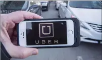  ?? THE CANADIAN PRESS/RYAN REMIORZ ?? The Uber logo is seen in front of protesting taxi drivers at the Montreal courthouse in February 2016.