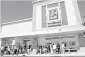  ?? AMY BETH BENNETT/SUN SENTINEL ?? Folks line up at a new Aldi food store in South Florida, waiting to take a look inside.