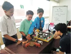  ?? Rap the Scrap ?? PELAJAR SK Pantai menerangka­n fungsi robot yang bertema seorang pengadil. kepada salah