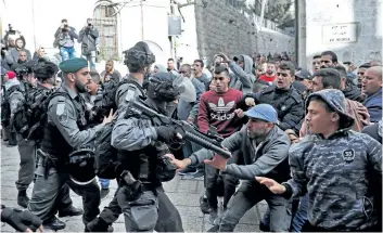  ?? THOMAS COEX/ GETTY IMAGES ?? Israeli security forces and Palestinia­n protesters confront each other in Jerusalem’s Old City on Friday. Four Palestinia­ns were killed by Israeli fire and dozens wounded in clashes across the West Bank and near Gaza’s border.