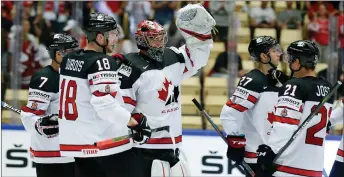  ?? AP PHOTO ?? Canadian goalie Darcy Kuemper, centre, celebrates with teammates after yesterday’s win against Germany.