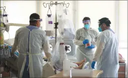  ?? Los Angeles Times/tns ?? Hospital doctors and nurses treat COVID-19 patients in a makeshift ICU wing at Harbor UCLA Medical Center on Dec. 29 in Torrance.