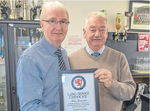  ??  ?? Downfield president Alex Duncan (left) is presented with a long-service award from East Region JFA secretary John Reilly. Alex has been with the Spiders for the last 21 years.