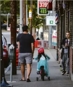  ?? ERIN CLARK/GLOBE STAFF ?? A father and his daughter biked down Mount Auburn Street in Watertown. According to Redfin, the average sale price of a home in Watertown in September was $836,000; in neighborin­g Newton, it was $1.28 million.