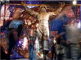  ?? — AFP ?? People ( above) walk past a statue of Yuri Gagarin as they visit the Museum of Cosmonauti­cs in Moscow. Officially, Yuri Gagarin died on a plane trying to avoid a weather balloon, but 50 years later, the disappeara­nce of the first man to go into space...